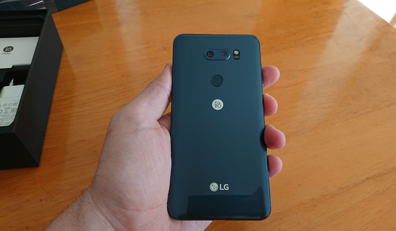 LG V30 en mano con la caja al fondo