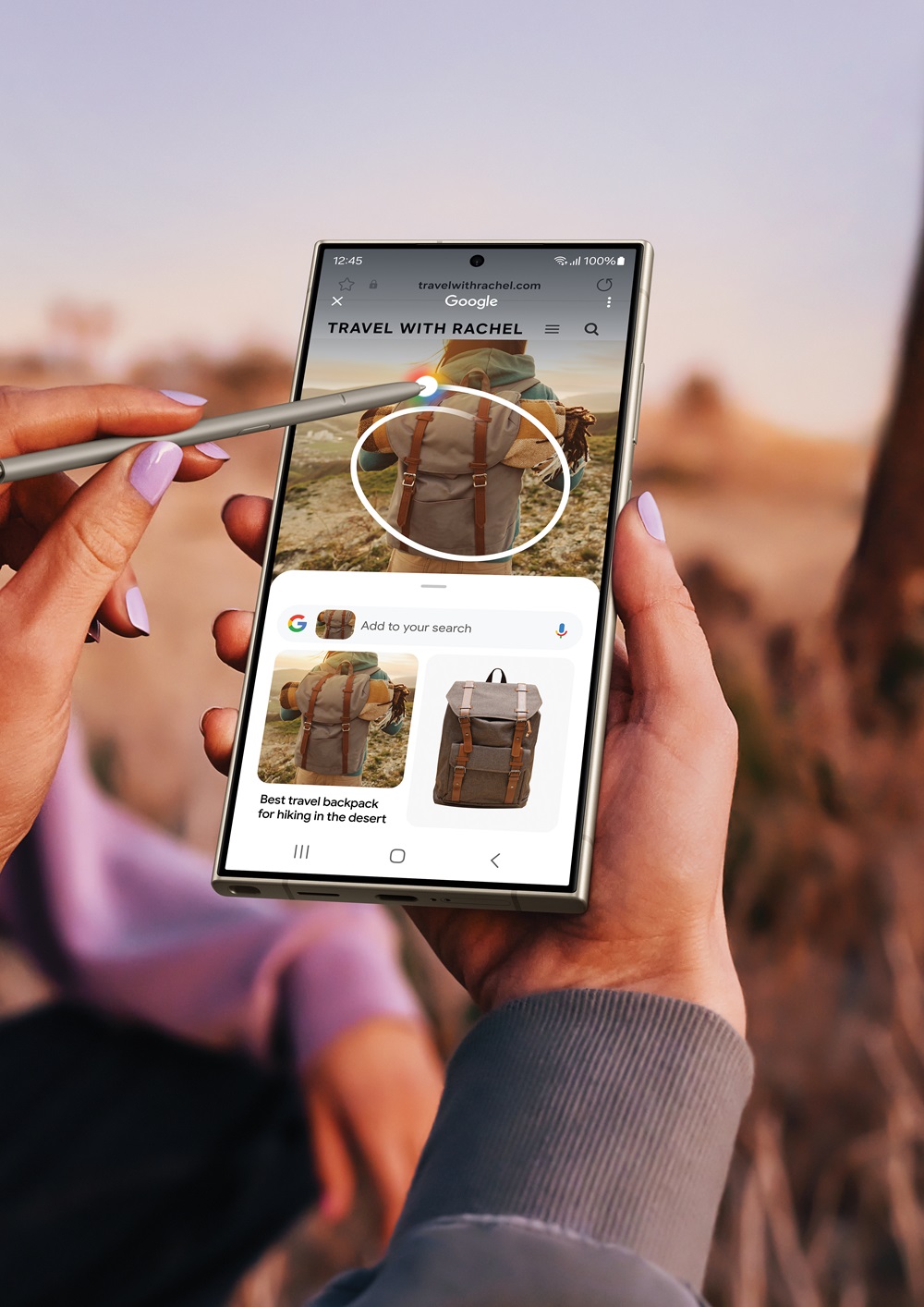 Vemos un paisaje montañoso como una mujer sujeta su Galaxy S24 Plus mientras utiliza su S-Pen accediendo a la nueva función de inteligencia artificial IA Cicrle to Search. Creando una selección circular con el lápiz de Samsung para buscar una mochila similar a la de la excursionista que se encuentra en la imagen del paisaje montañoso. Para encontrar rápidamente a través de buscador de internet imágenes similares por Search AI.