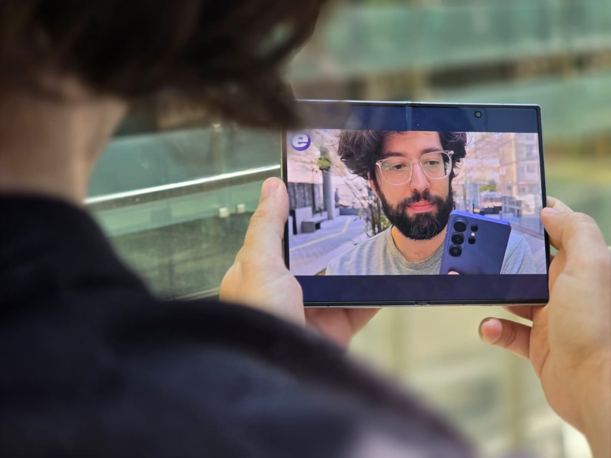 Samsung Galaxy Z Fold8 desplegado en horizontal durante una videollamada, sostenido con ambas manos.