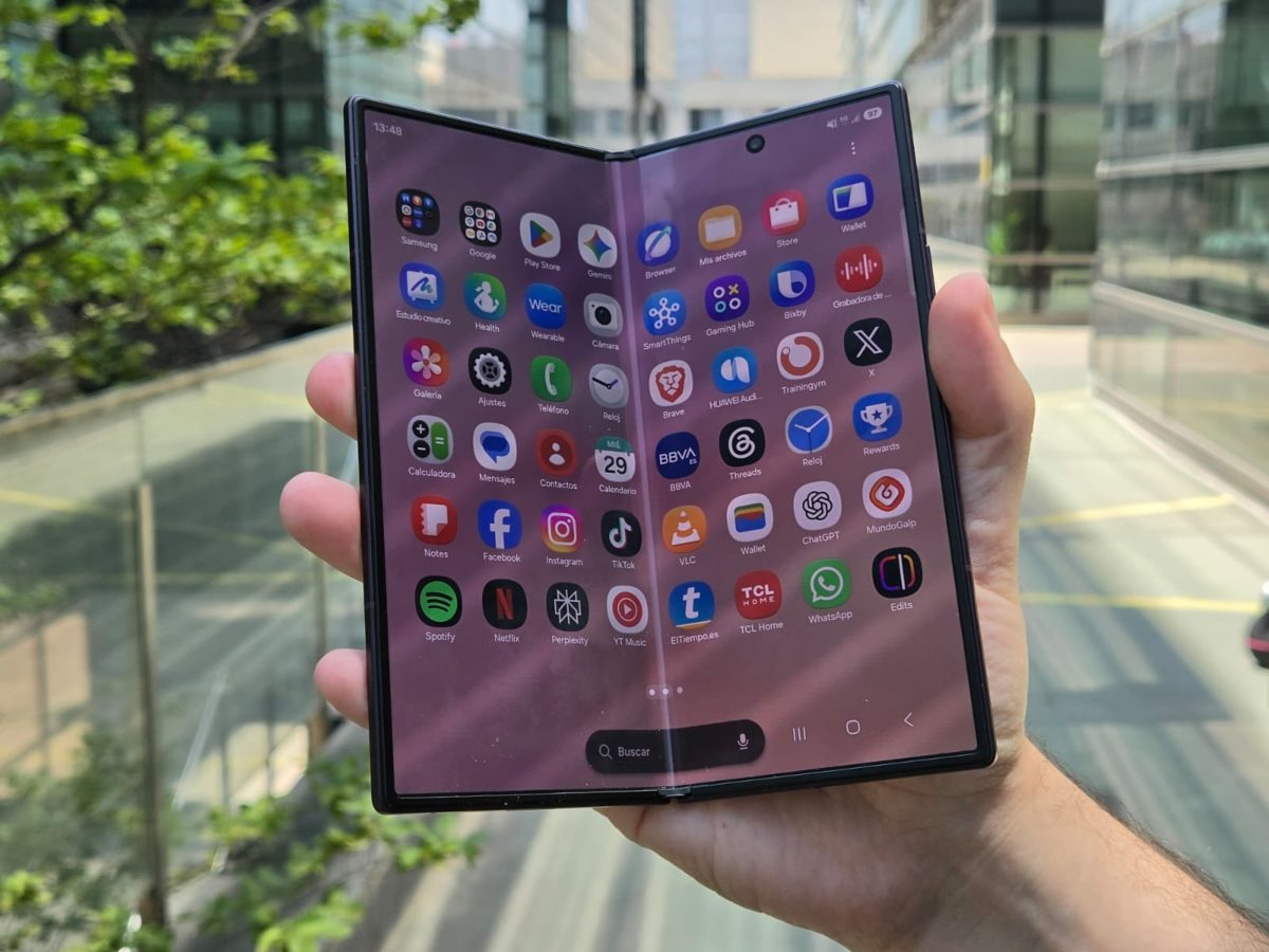 En la mano un móvil plegable Samsung Galaxy Z Fold8 Ultra desplegado, mostrando varias aplicaciones abiertas a la vez en la pantalla principal mediante la función multiventana.